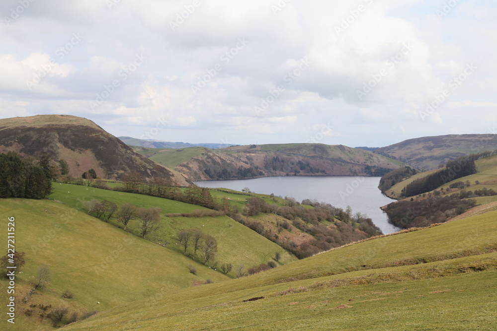 A view across rolling hills and farmland to Llyn Clywedog, Powys, Wales.