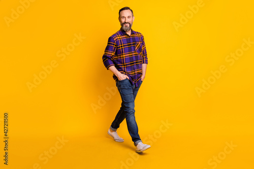 Full length body size photo of businessman walking on meeting smiling isolated on bright yellow color background