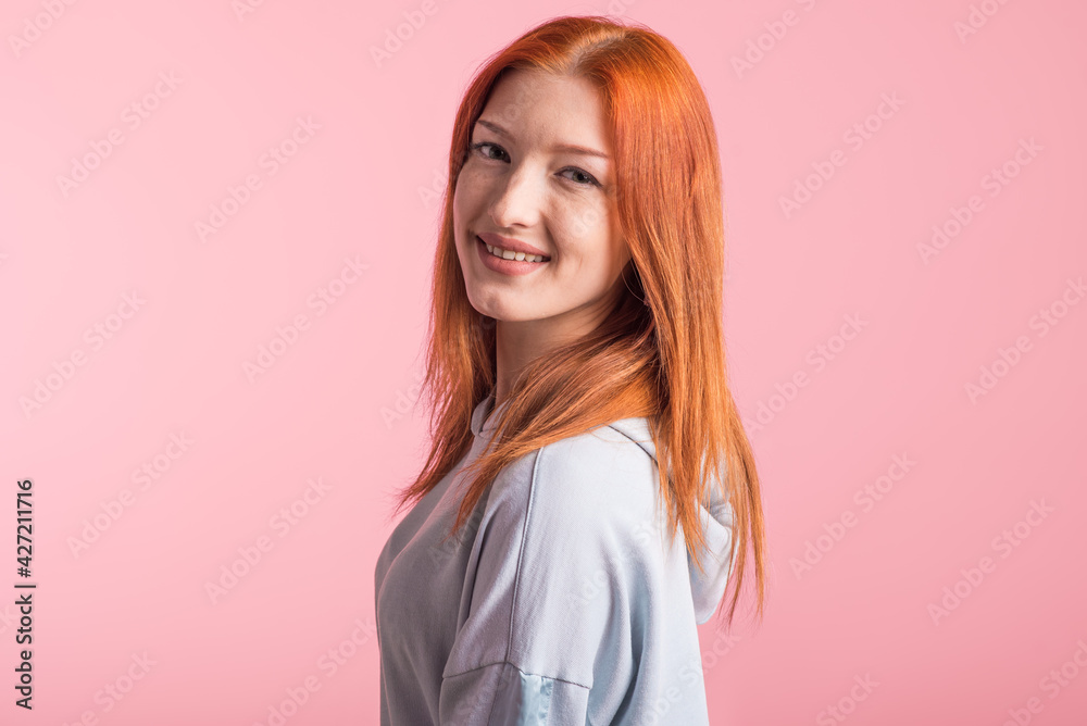 Portrait of a satisfied redhead girl in the studio on a pink background Portrait of a satisfied redhead girl in the studio on a pink background