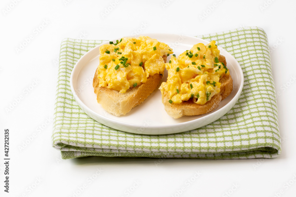 Scrambled eggs served on bread toast on white background Scrambled eggs served on bread toast on white background