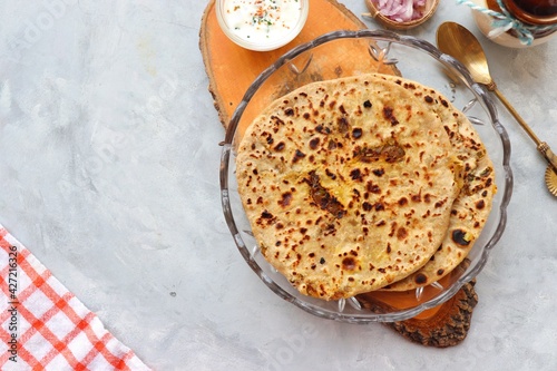 Indian traditional Hot Onion Paratha with yogurt. Indian onion stuffed Flatbread. also known as Pyaz ke parathe in Hindi. over a light background with copy space. photo