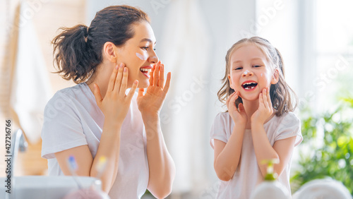 Mother and daughter caring for skin