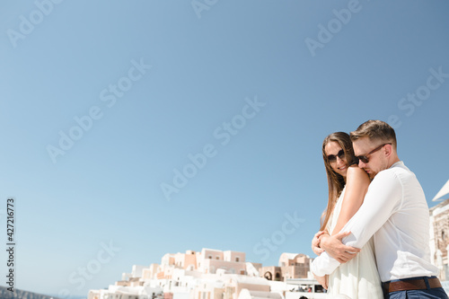 Happy couple hugging and laughing together with a view of Santorini © Oleksandr