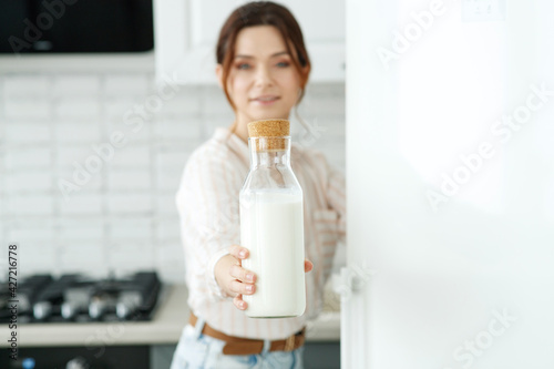 The woman is drinking milk in her kitchen. High quality photo.