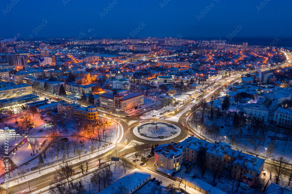 Beautiful evening top view of the city. Evening, night illumination in the city. Winter city in the snow.