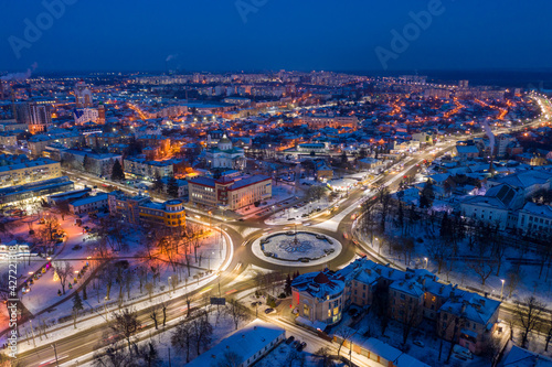 Beautiful evening top view of the city. Evening, night illumination in the city. Winter city in the snow.