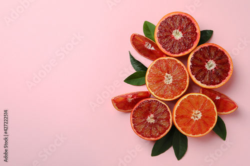 Red oranges and leaves on pink background