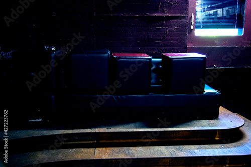 eingebautes gepolstertes Sofa in leere/m Club/Disko, auf dem Hocker stehen photo