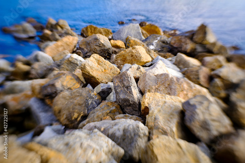 Rocks and stones on a the shore of a blue sea or lake