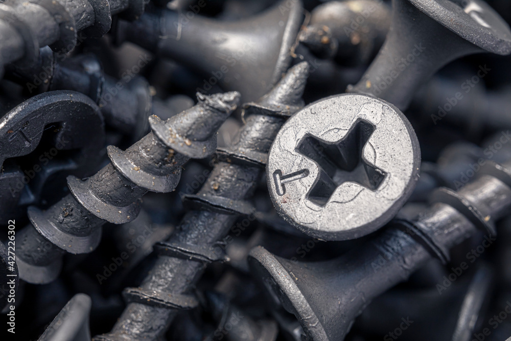 A handful of self-tapping screws for wood. Construction abstraction. Industrial background.