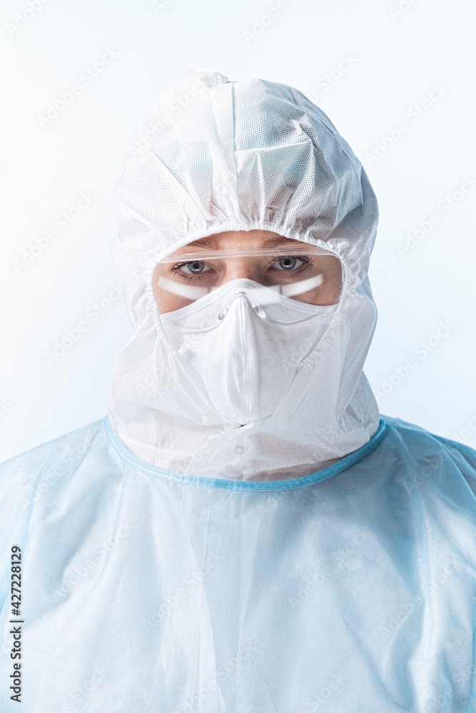 Portrait of doctor wearing protecting suit and mask on blue back Portrait of doctor wearing protecting suit and mask on blue back
