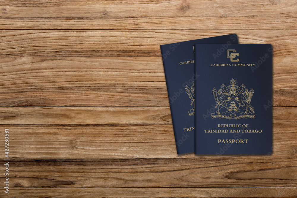 Trinidad and Tobago passports are issued to Trinidad and Tobago citizens for international travel, two passports on a wooden background Trinidad and Tobago passports are issued to Trinidad and Tobago citizens for international travel, two passports on a wooden background