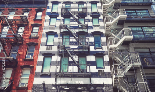 Old buildings with iron fire escapes, color toning applied, New York City, USA.