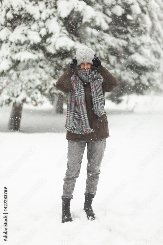Portrait of attractive woman in warm clothes in winter snowy weather outdoors Portrait of attractive woman in warm clothes in winter snowy weather outdoors