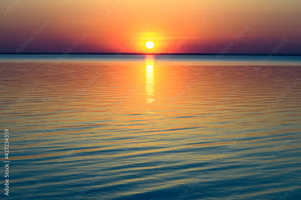 Obraz premium Bright beautiful sunset at the calm sea. Solar disk over water.