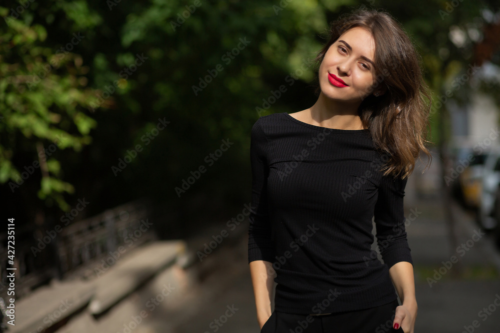 Happy woman dressed in black apparel walking at the street Happy woman dressed in black apparel walking at the street