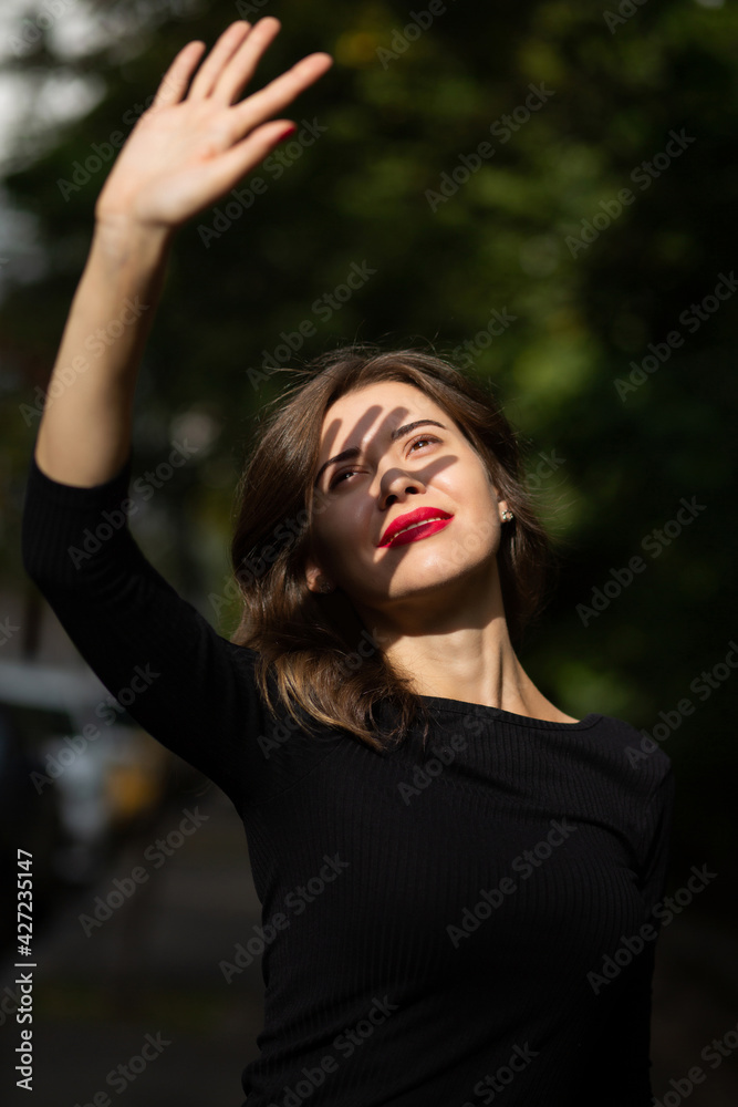 Elegant woman covers her face from sun rays