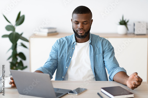 Coping With Working Stress. Portraif Of Calm Black Man Meditating At Workplace