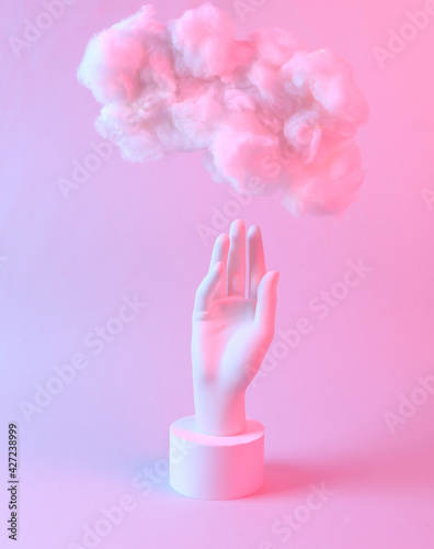 Modern abstract composition of hand and floating fluffy cloud in blue pink neon gradient light. Creative idea. Concept art. Minimalism. Surrealism