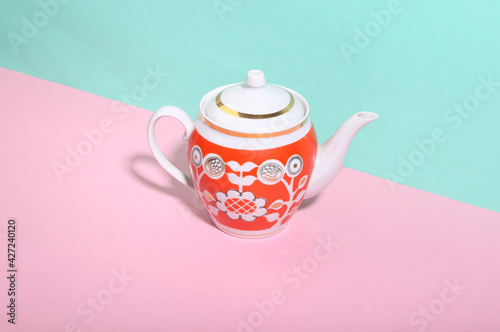 Ceramic retro teapot on blue-pink background. Minimalism. Trendy shadow. Creative layout