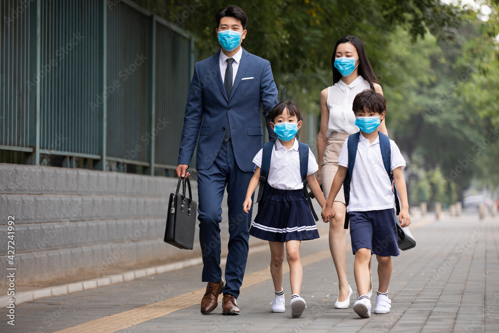 Young family wearing surgical masks and walking outdoors Young family wearing surgical masks and walking outdoors