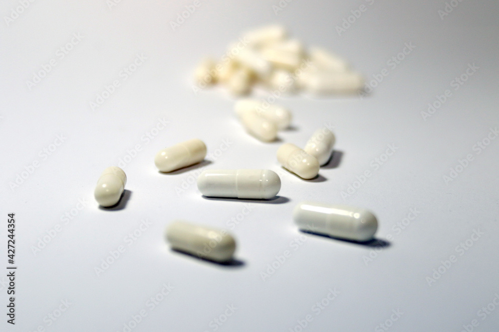 pills and capsules spilled on white background