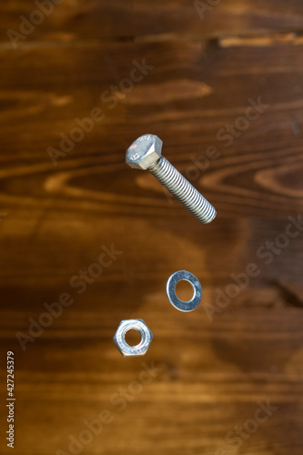 falling screw, washer and nut on blurred background
