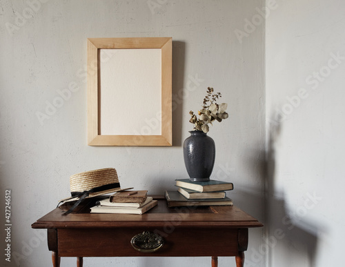 Wooden frame mockup. composition with notebook, books, vase with dried flowers on an old wooden table. Modern french interior.