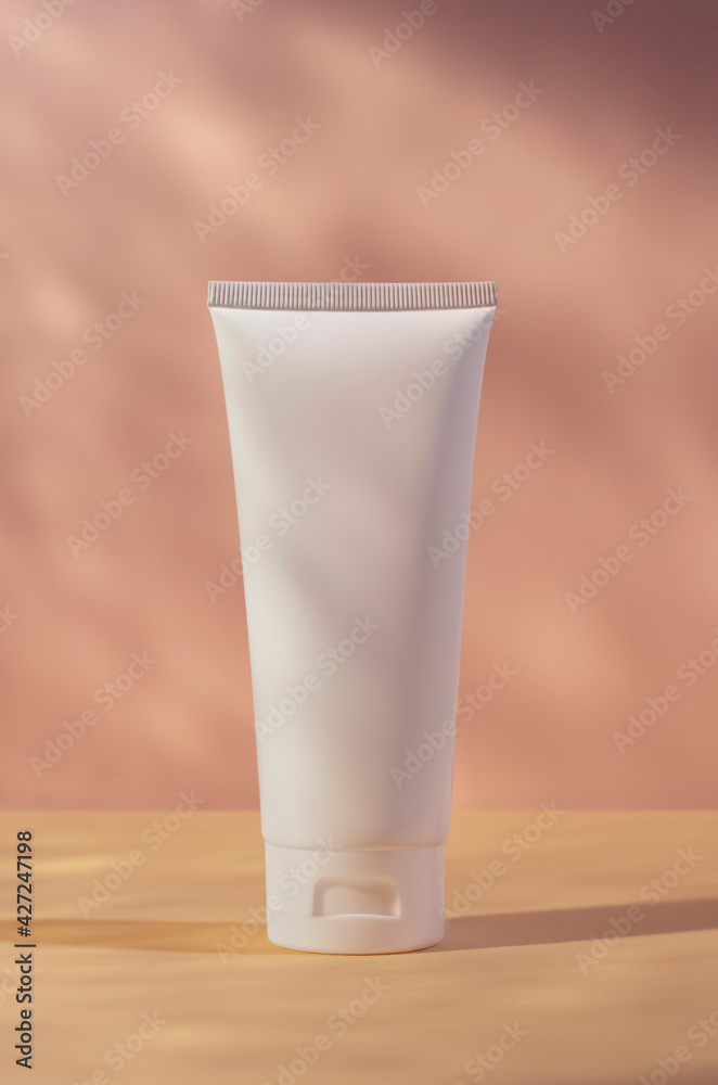 white cream tube mockup isolated on pink blurred background, cosmetics mock up