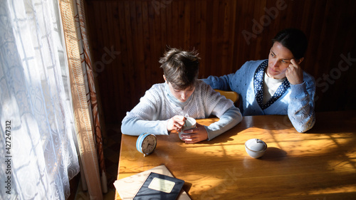 Portrait of sad poor mature mother with small daughter indoors at home, poverty concept. photo