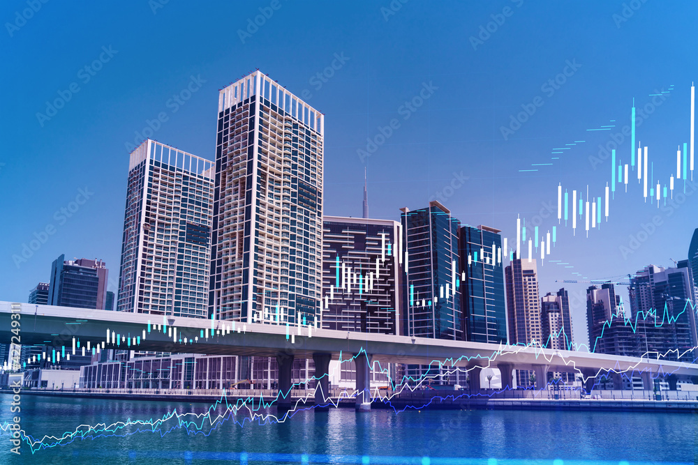 Naklejka premium Skyscrapers of Dubai business downtown. International hub of trading and financial services of Western Asia. FOREX graph and chart concept. Double exposure. Dubai Canal waterfront.