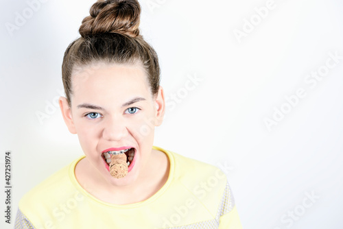 Quadro em tela Beautiful girl holds in teeth with braces cork from champagne