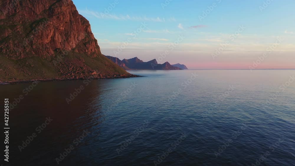 Flying Low Over Ocean Calm Waters as Warm Summer Evening Sun Shines on Mountain Flying Low Over Ocean Calm Waters as Warm Summer Evening Sun Shines on Mountain
