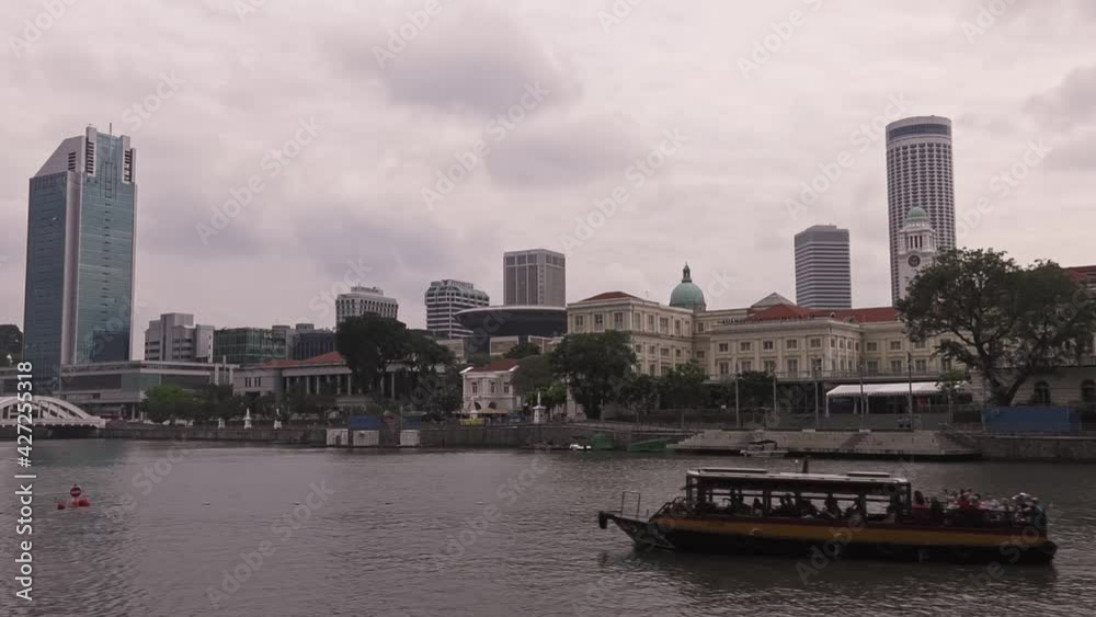 Boat crossing Singapore River near Historical Boat Quay during overcast day - Wide static shot Boat crossing Singapore River near Historical Boat Quay during overcast day - Wide static shot