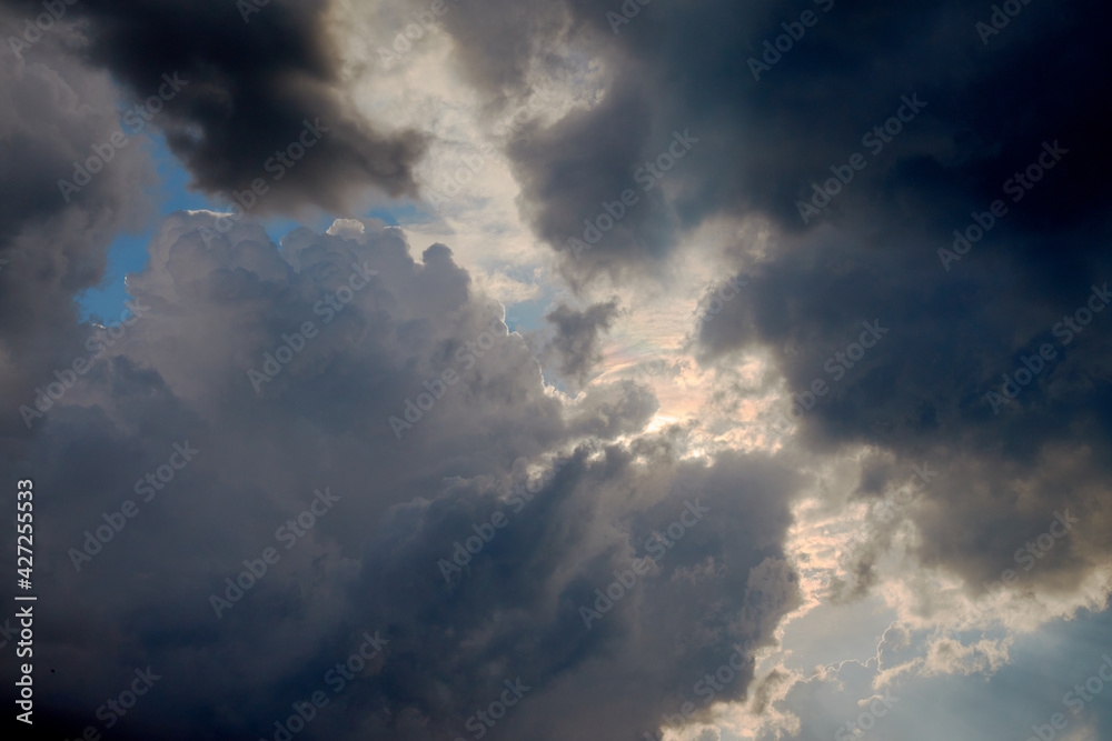 A picture of dark heavy clouds with the sun shining from the back. A picture of dark heavy clouds with the sun shining from the back.