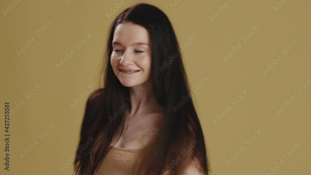 Young happy playful lady with vitiligo pigmentation dancing, playing with her hair, olive studio background, slow motion Young happy playful lady with vitiligo pigmentation dancing, playing with her hair, olive studio background, slow motion