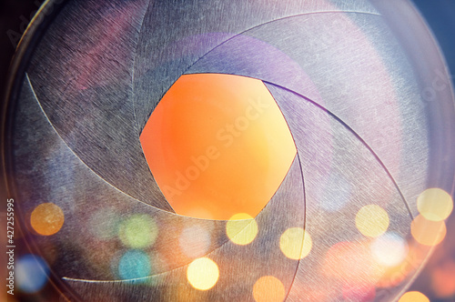 The camera lens on the background of the fiery city lights. Concept on the topic of news, media, information. Camera Lens background. photo
