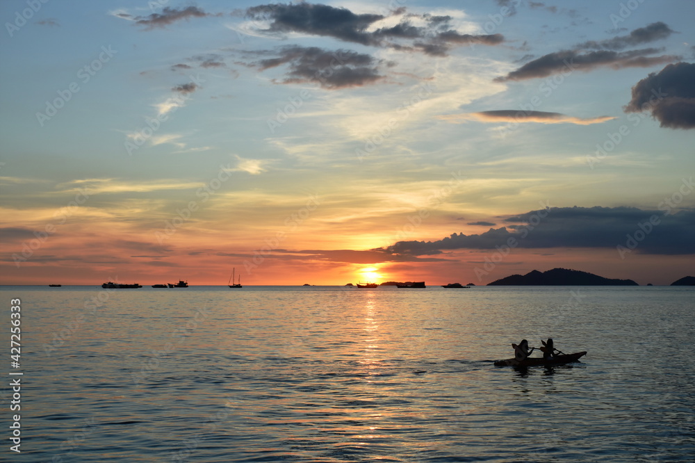 silhouette kayak boat and landscape of sunset on sea from Lipe island travel location in Thailand