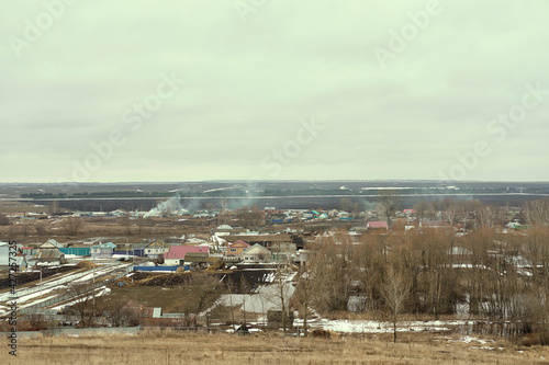 typical suburb near Moscow. Cottages, fields and forest belt aerial view. Early spring