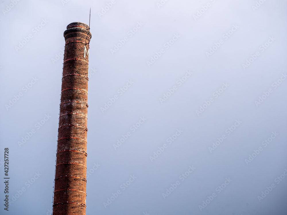 Old bricks factory chimney with bricks. blue sky background. color