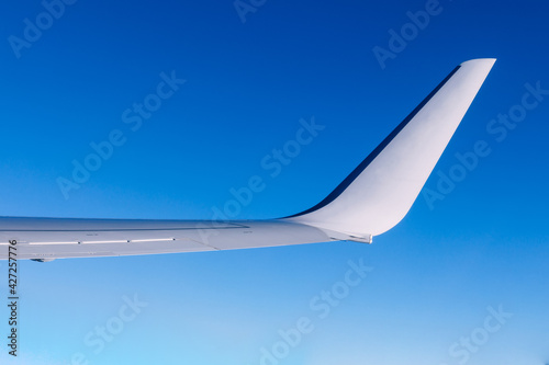 Airplane wing flying above the clouds. People look at the sky from the window of the plane, using air transport to travel.