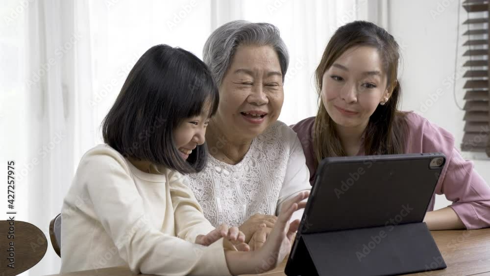 Senior woman using video call at living room. Woman and Daughter join to video call with grandmother. They talking funny story together. Senior woman using video call at living room. Woman and Daughter join to video call with grandmother. They talking funny story together.