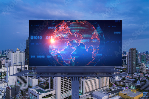 Hologram of Earth planet map on billboard over night panoramic cityscape of Bangkok. The concept of international companies in Southeast Asia.