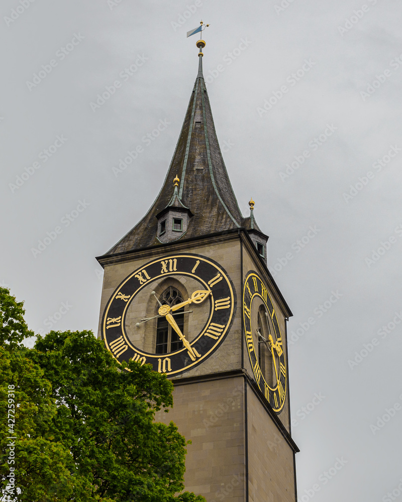 Saint Peter church clock tower under cloudy sky in Zurich, Switzerland