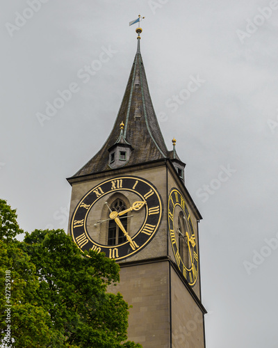 Saint Peter church clock tower under cloudy sky in Zurich, Switzerland photo