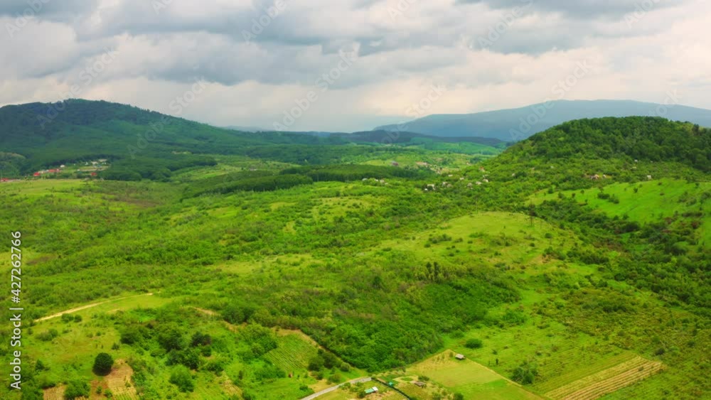 drone flying forward to the mountains village surrounded forest with green foliage cloudy sky spring landscape drone flying forward to the mountains village surrounded forest with green foliage cloudy sky spring landscape