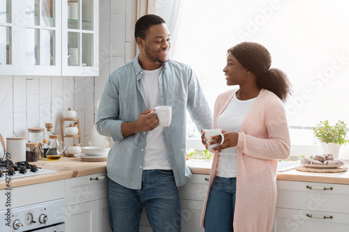 Affectionate Black Spouses Drinking Coffee And Spending Time In Kitchen Together