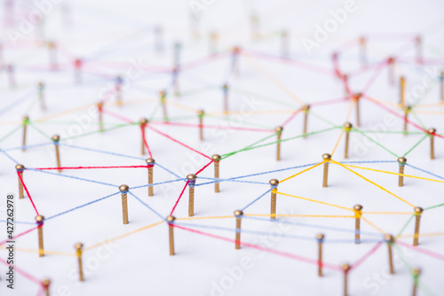 abstract web line connection of color yarn from nail node to node on white background , networking concept photo