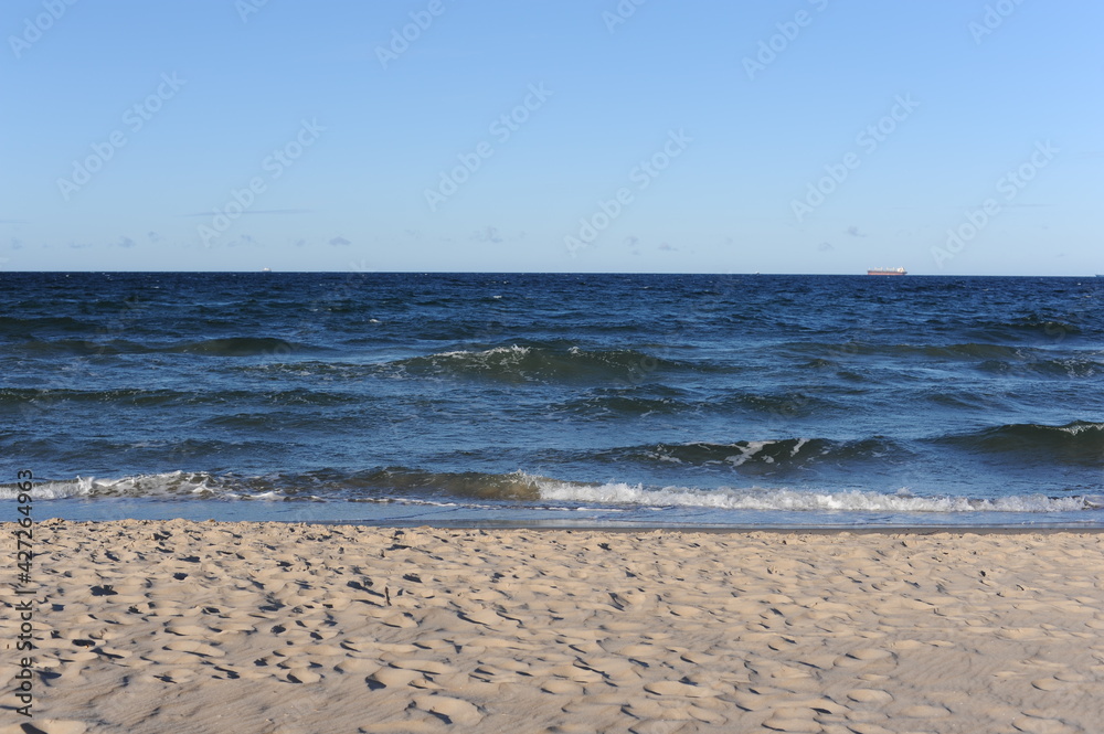 Turquoise sea water waves with horizon and blue sky on a sunny day at the seaside coast of Baltic Sea in Europe
