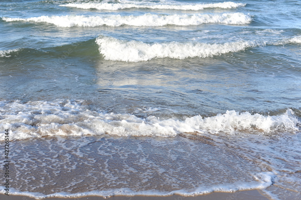 Fototapeta premium Turquoise sea water waves with horizon and blue sky on a sunny day at the seaside coast of Baltic Sea in Europe